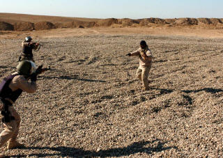 Officers from the 3rd Public Order Battalion react to a gunman during a training exercise at Forward Operating Base
                                    Seven in December. The officers were preparing to take over policing duties in the city of Samarra at the end of the month.
                                    They were being trained by military and civilian officials, including George Clark, an international police officer and Philadelphia
                                    resident who played the role of the gun-wielding terrorist. (Photo by Spc. Ismail Turay Jr., 196th MPAD)